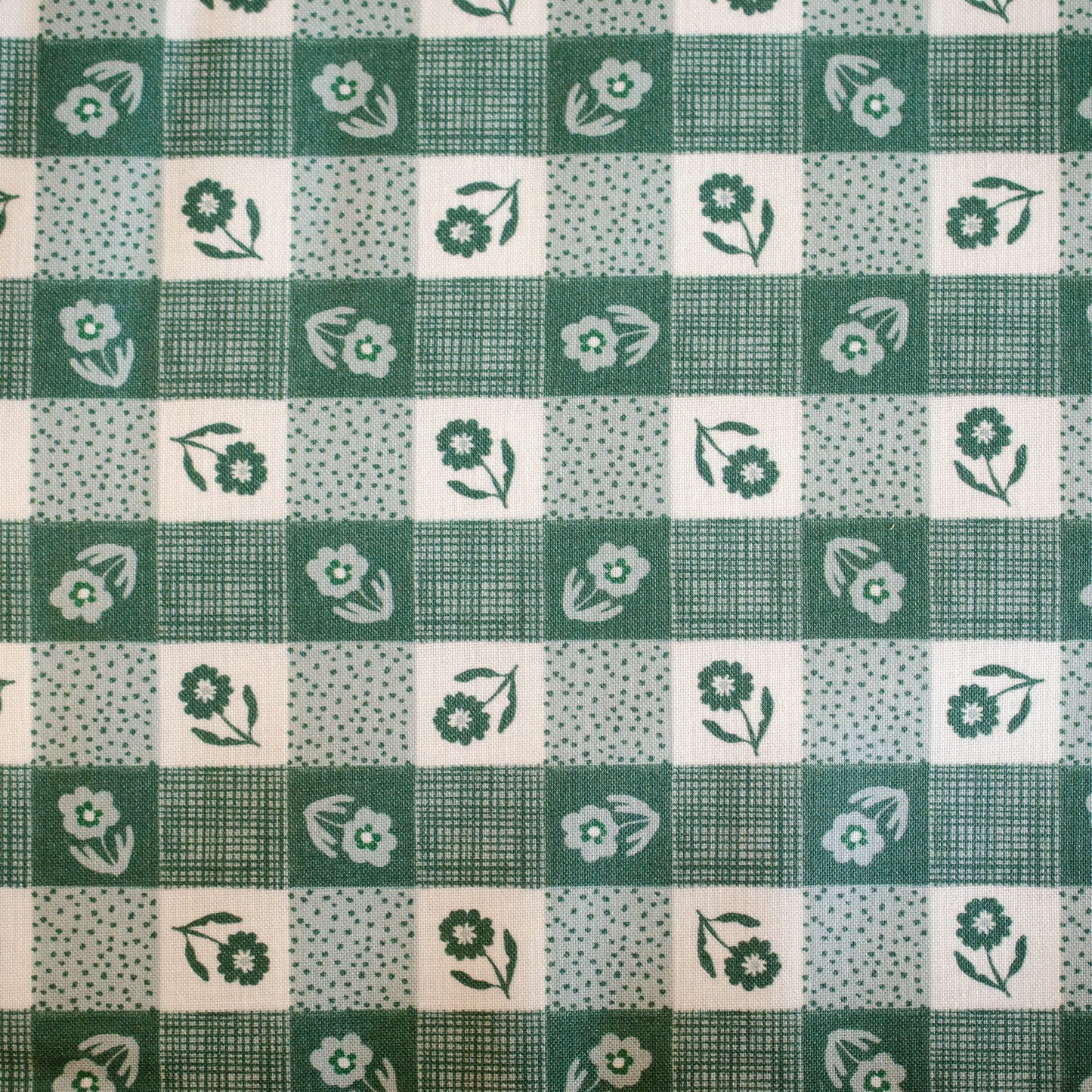 Green and white checkered fabric with floral patterns