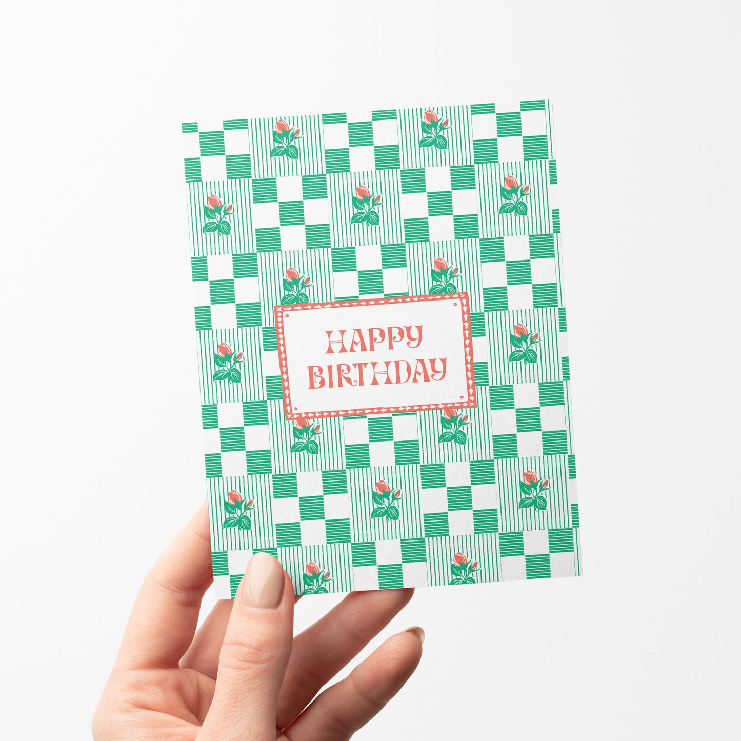 A beautifully designed birthday card featuring a soft green checkered pattern interspersed with delicate rosebud illustrations. The elegant yet playful design makes it a perfect choice for celebrating birthdays with a touch of charm and sophistication.