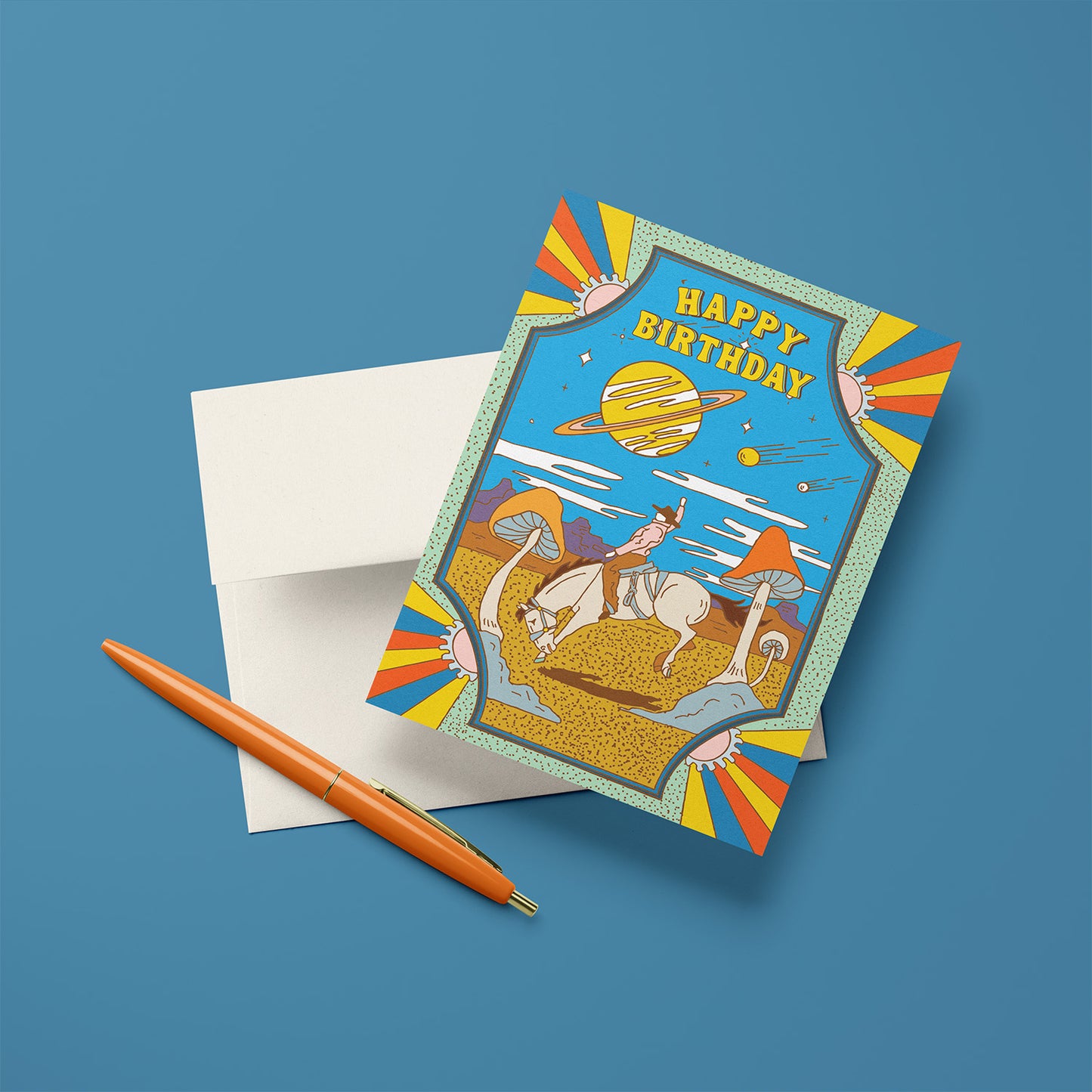 Psychedelic birthday card with cowboy on horseback in desert, giant mushrooms, ringed planet, and shooting stars.