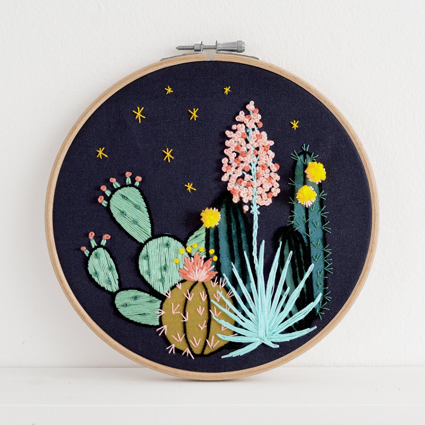 Embroidery kit with fabric, wooden hoop, thread, needle, and instructions for beginners, featuring a night time desert scene
