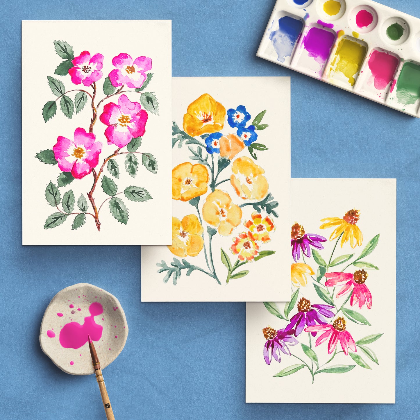 Wildflowers watercolor kit with watercolor paper, guide book, and color swatches on a gray background