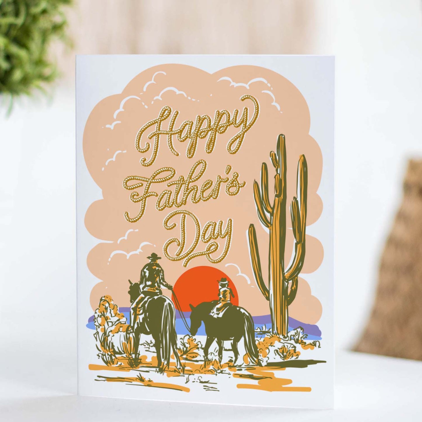 Father’s Day card with an illustration of a father and child on horses in a desert landscape.