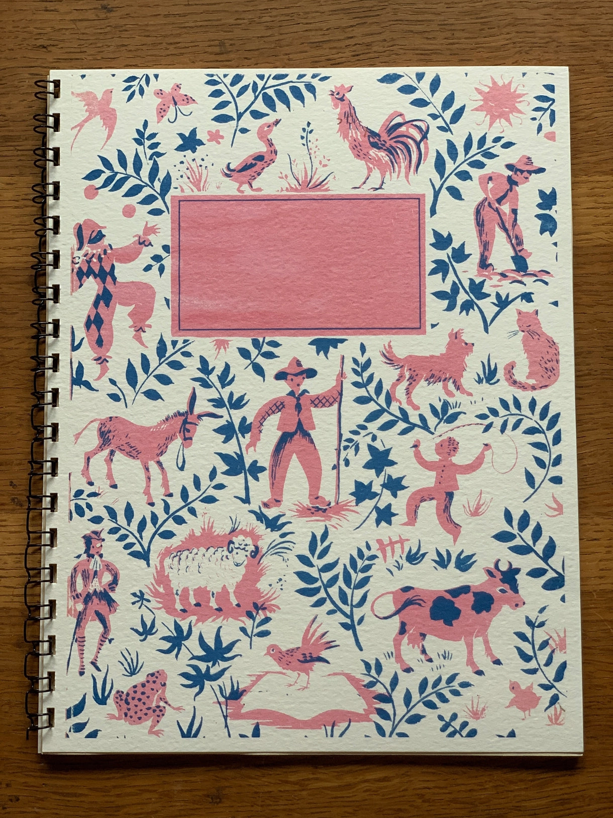 colorful softcover spiral-bound notebook featuring a French story book inspired design. lined interior pages.