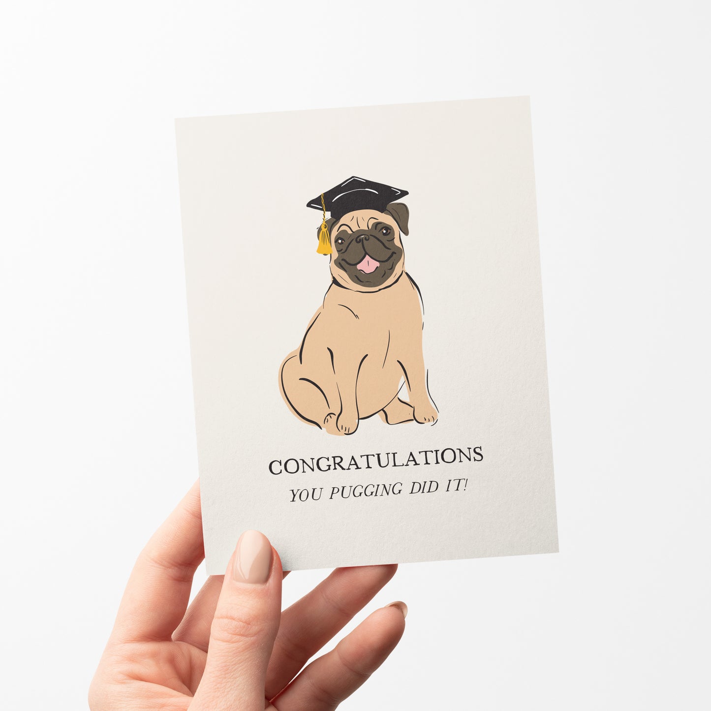 A fun and adorable greeting card featuring a happy pug wearing a black graduation cap with a gold tassel. The card displays the message "Congratulations" with the playful pun, "You pugging did it!" Perfect for celebrating graduations and academic milestones