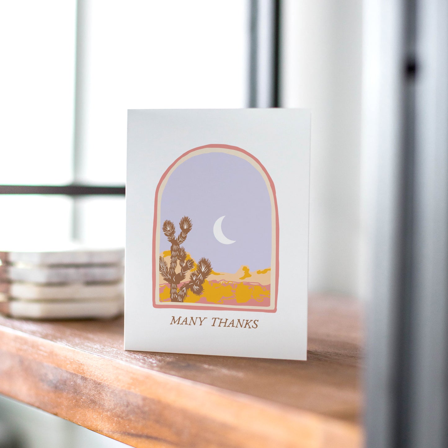 A beautifully illustrated thank-you card featuring a serene desert vista with a prominent Joshua tree. The card includes the message "Many Thanks," making it a thoughtful choice for expressing gratitude with a touch of natural beauty.