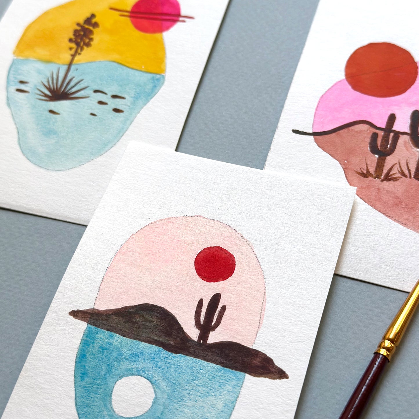 Colorful abstract artworks on paper with a paintbrush.