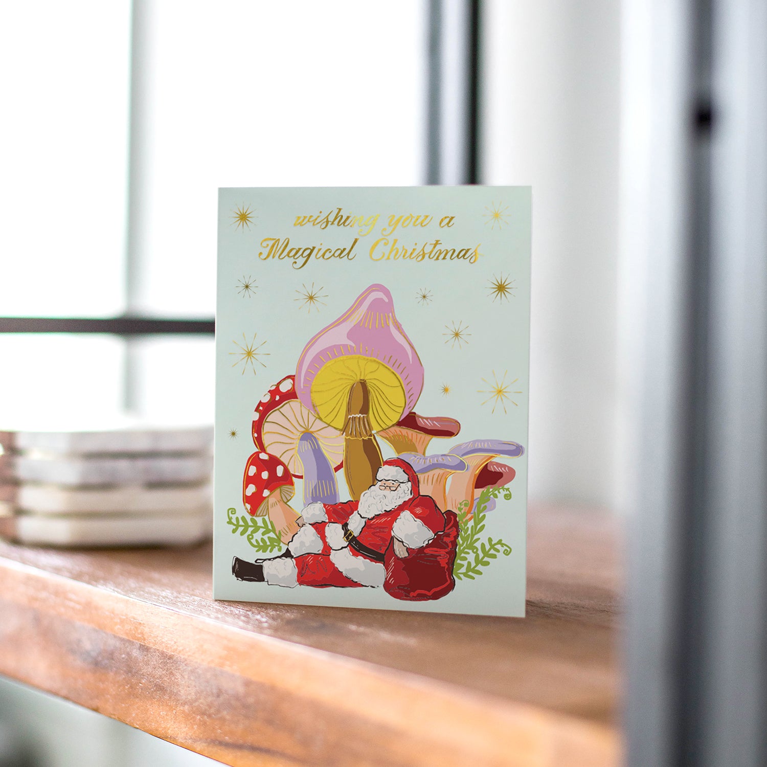 Sroomin' Santa holiday card with a whimsical Santa illustration nestled in a colorful grove of mushrooms, perfect for a playful holiday greeting, blank inside.