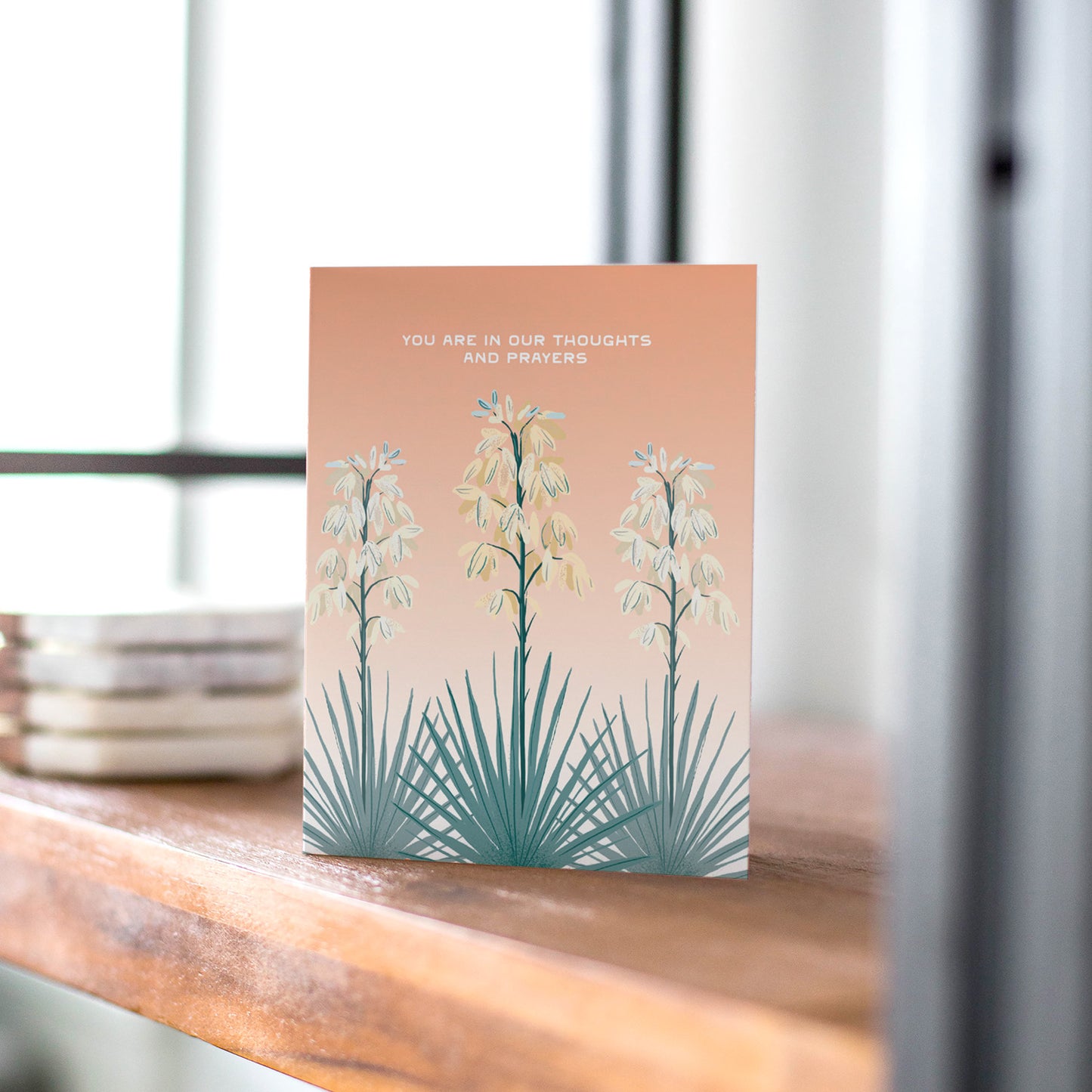 Illustration of yucca blooms with 'You Are in Our Thoughts and Prayers' on a blank sympathy card.