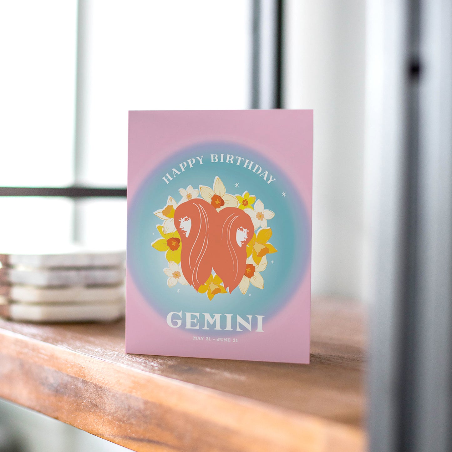 Playful birthday card with the Gemini symbol, featuring dual imagery and vibrant colors to represent Gemini's lively and curious nature.