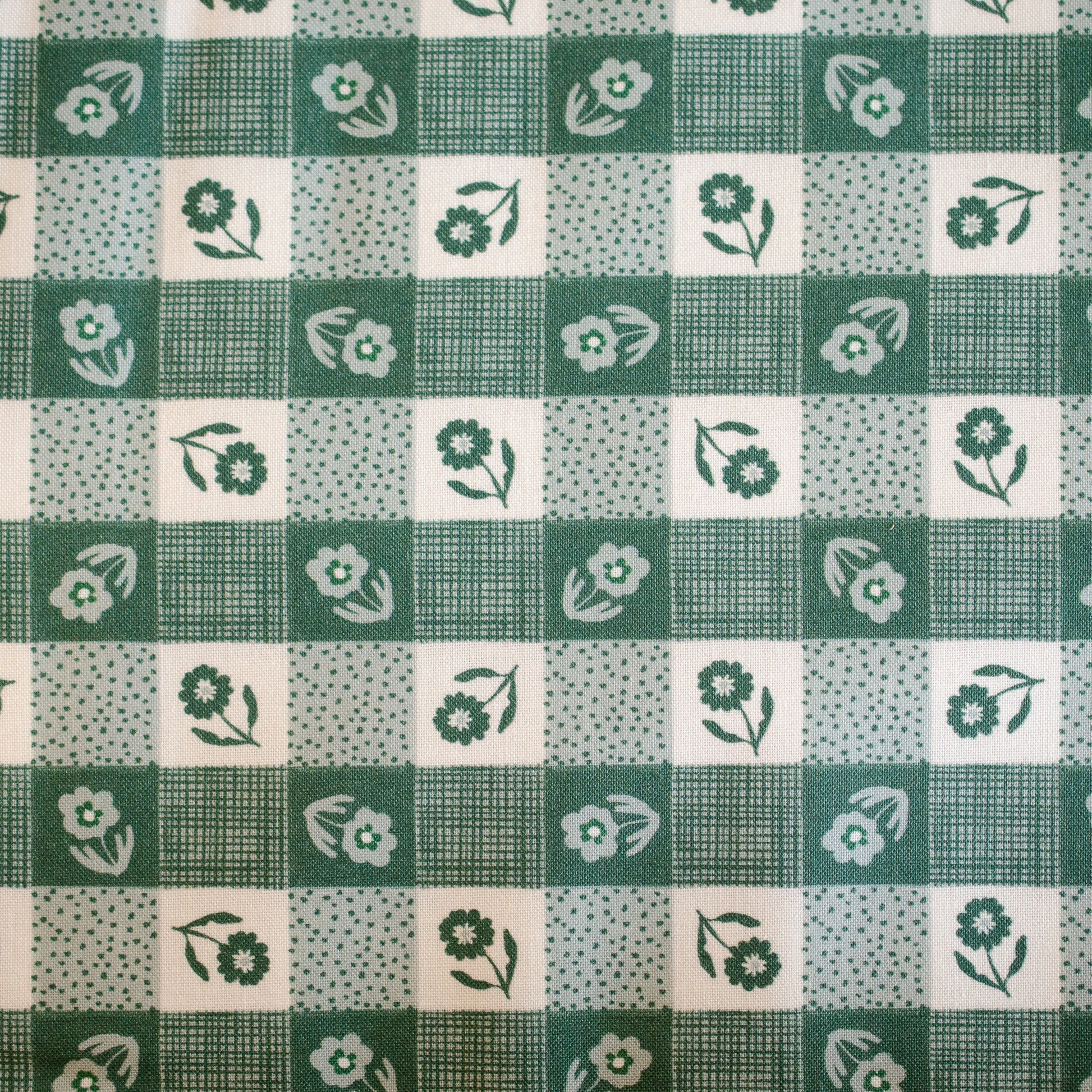 Green and white checkered fabric with floral patterns
