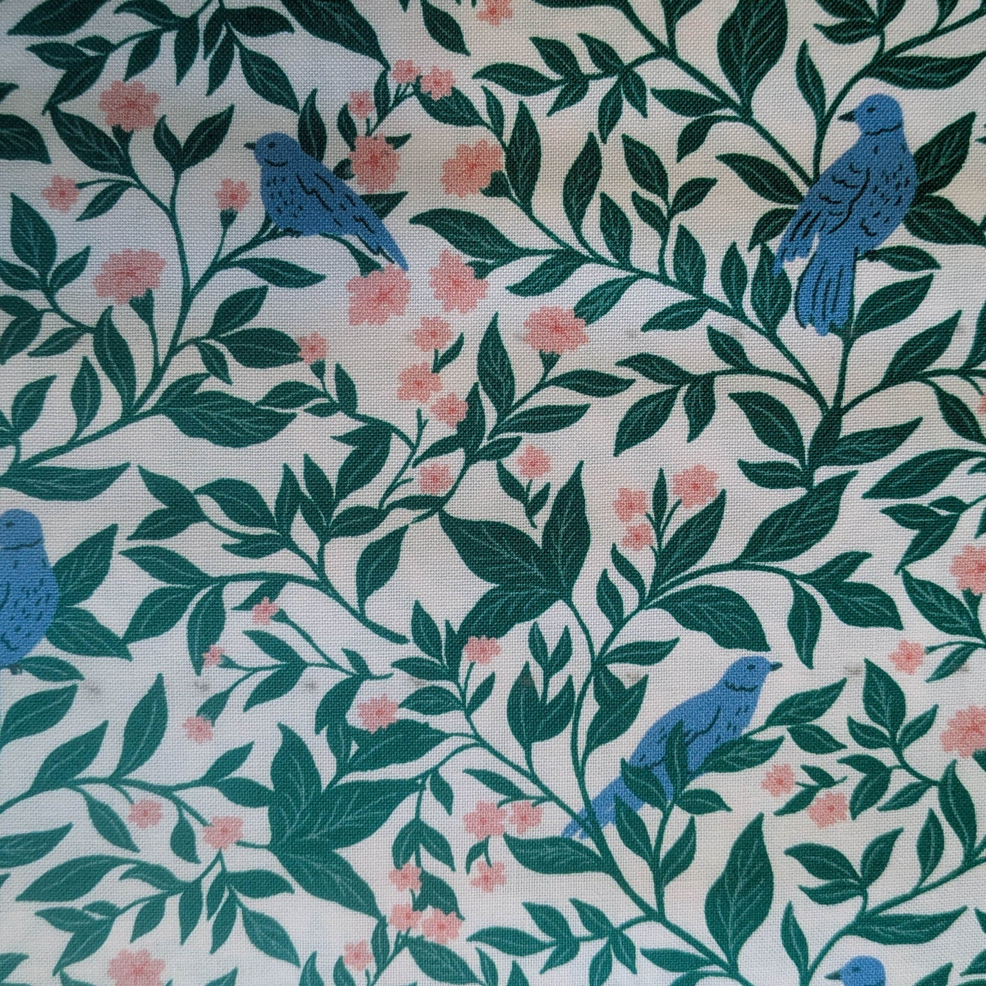 Fabric with blue birds and green leaves pattern on a white background