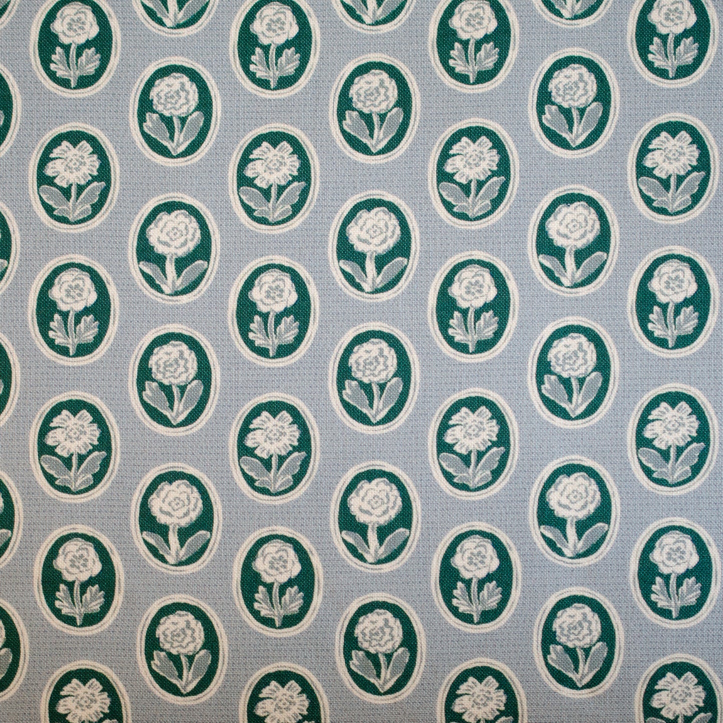 Pattern of white flowers in green circles on a blue background