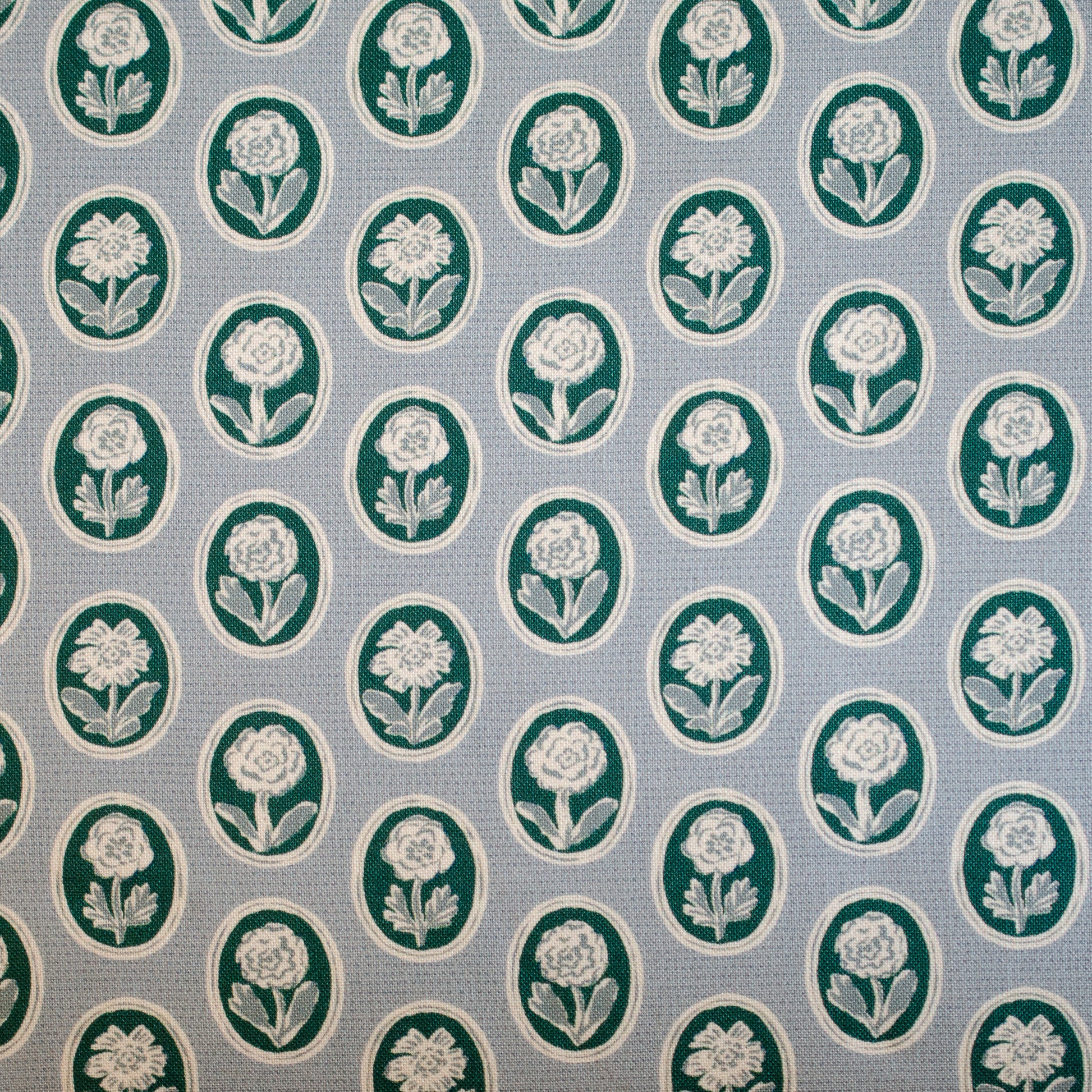 Pattern of white flowers in green circles on a blue background