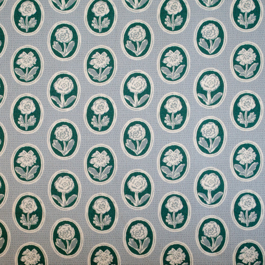 Pattern of white flowers in green circles on a blue background