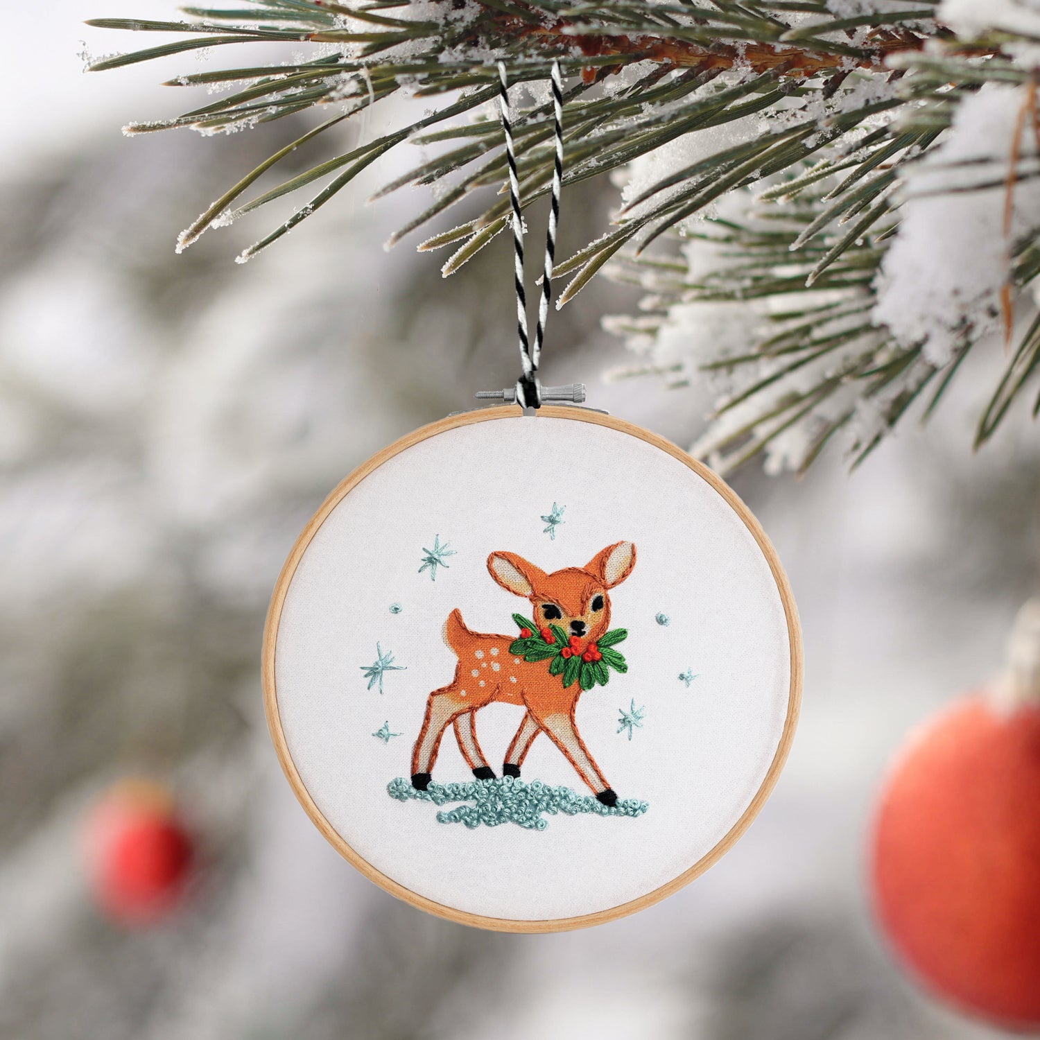 Embroidered deer ornament with a wreath on a Christmas tree
