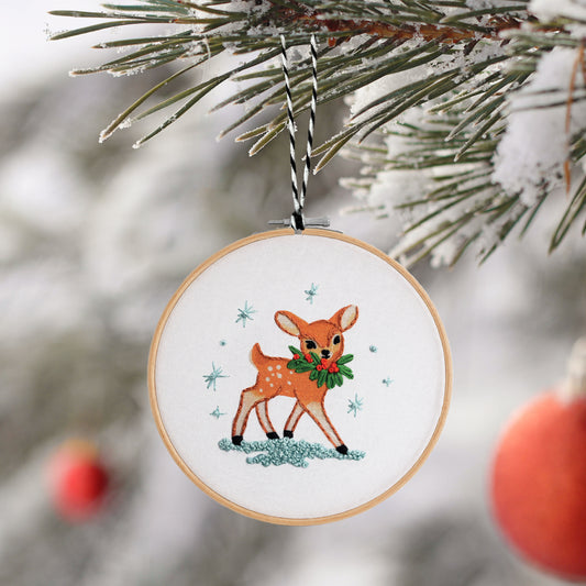 Embroidered deer ornament with a wreath on a Christmas tree