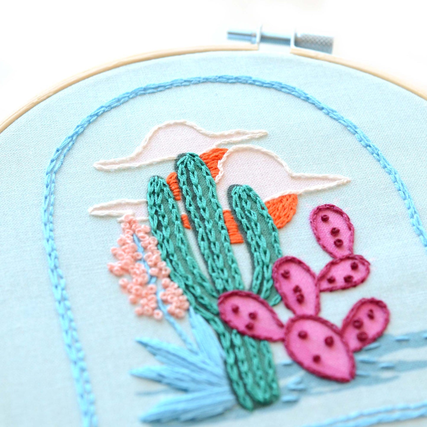 Embroidery patch kit with fabric, wooden hoop, thread, needle, and instructions for beginners, featuring a desert scape