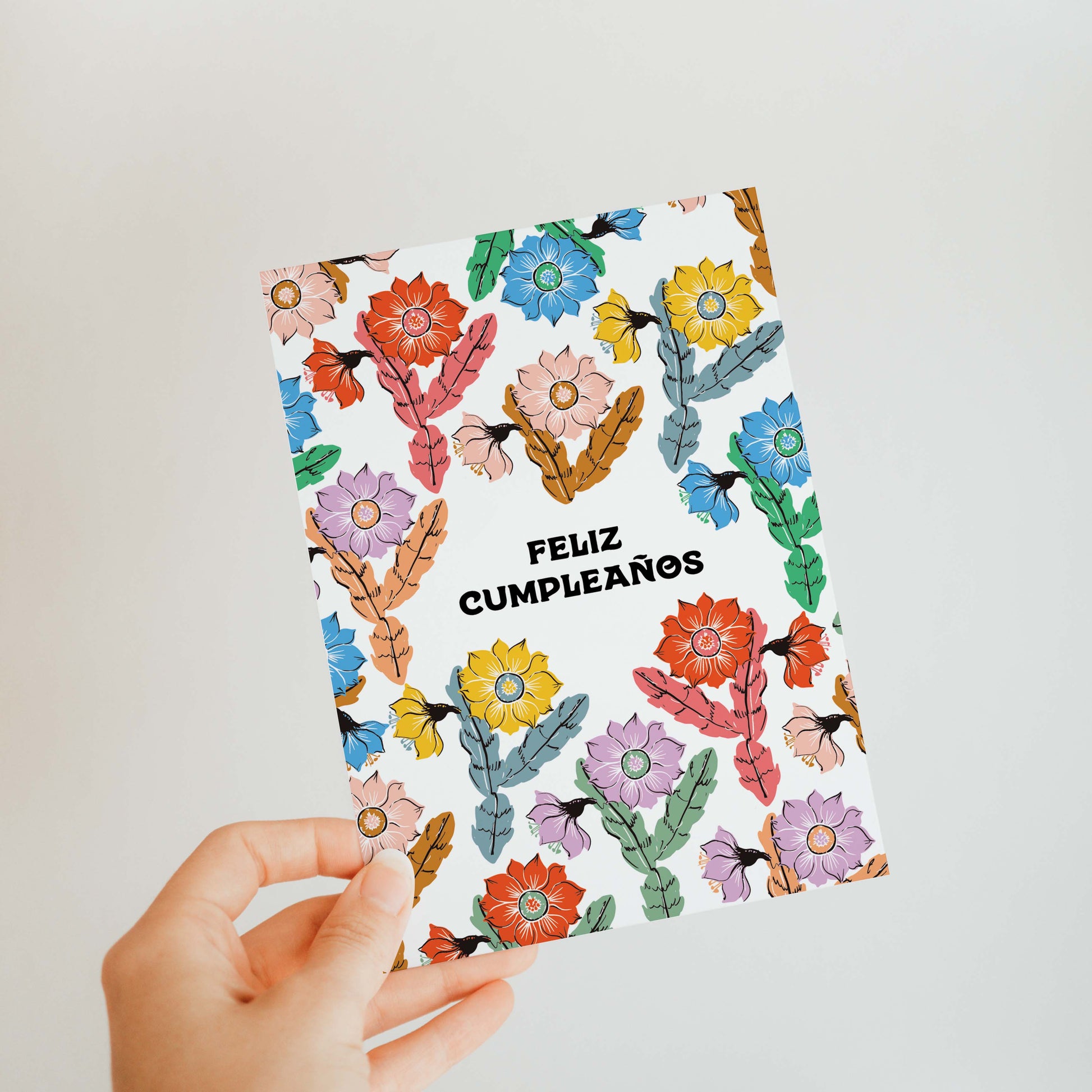 Elegant birthday card with blooming orchid cacti and vibrant colors, featuring the phrase 'Feliz Cumpleaños' for a festive celebration.