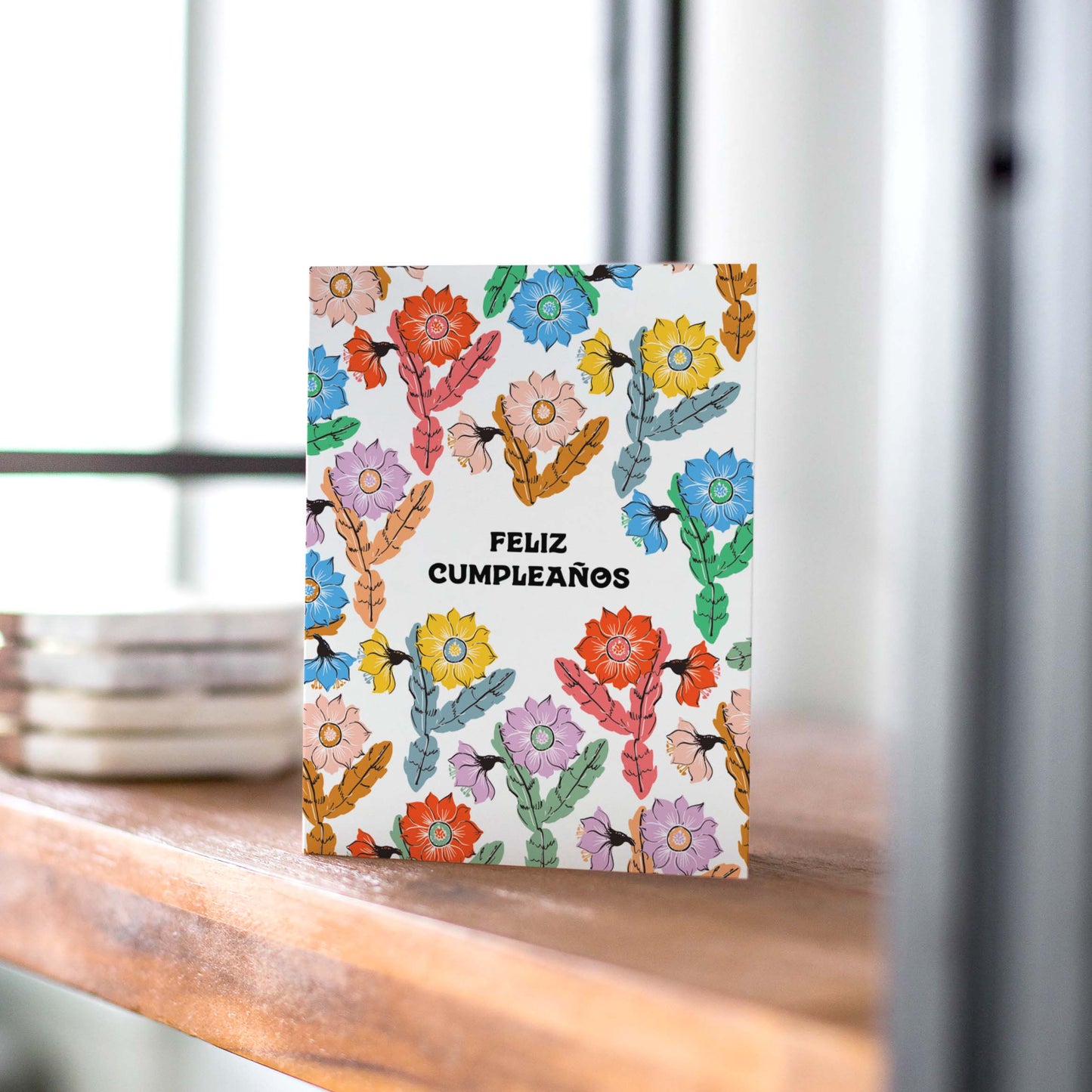 Elegant birthday card with blooming orchid cacti and vibrant colors, featuring the phrase 'Feliz Cumpleaños' for a festive celebration.