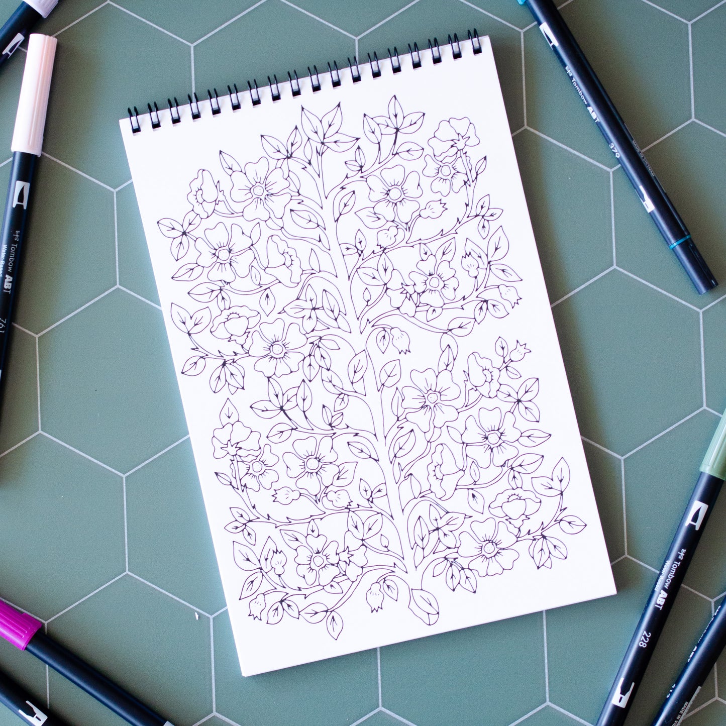 Cottage Garden Coloring Book with 22 pages of hand-drawn illustrations featuring flowers, bees, butterflies, and a whimsical garden gnome. Spiral-bound adult coloring book with intricate botanical designs, perfect for relaxation and creativity.