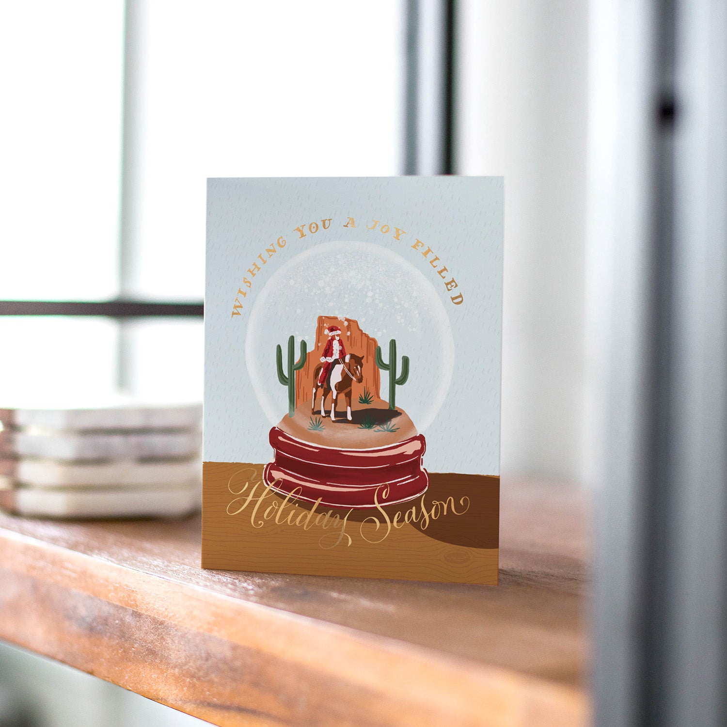 Cowboy Santa snowglobe holiday card, with a whimsical cowboy Santa inside a snowglobe, perfect for holiday fun, blank inside.