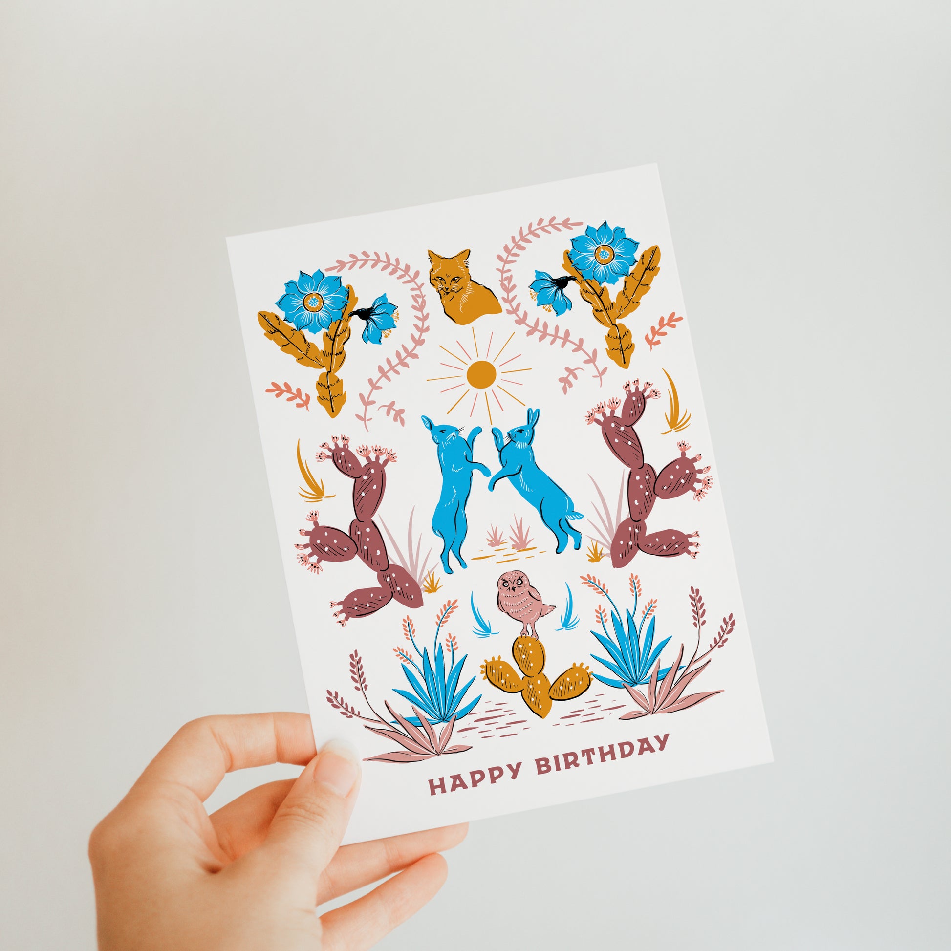 Unique birthday card featuring desert folk art, with intricate cacti and desert animal illustrations in vibrant colors inspired by desert landscapes and cultures.