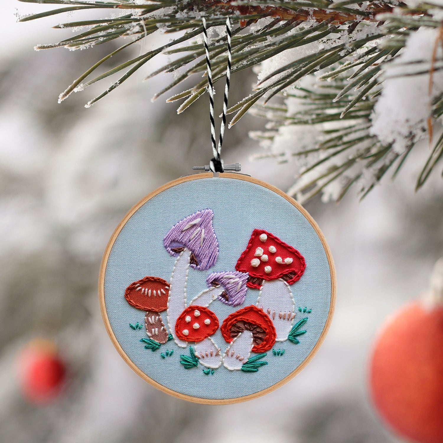 Embroidery Ornament kit with fabric, wooden hoop, thread, needle, and instructions for beginners, featuring a group of different colored mushrooms