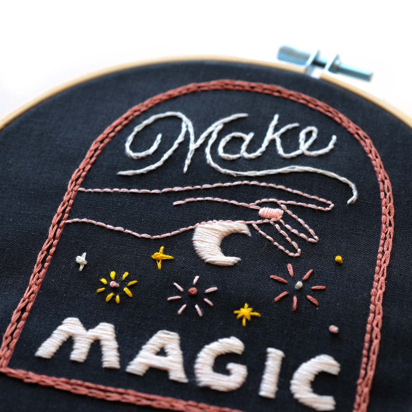 Embroidery patch kit with fabric, wooden hoop, thread, needle, and instructions for beginners, a stary sky in a hand with the saying "make magic"