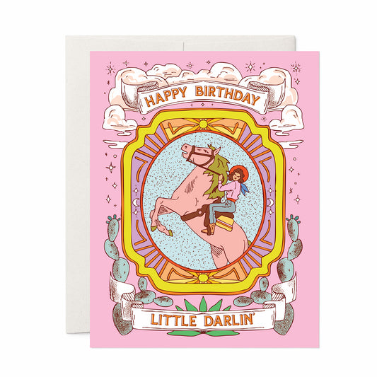 Western-themed pink birthday card with cowgirl riding a horse and the text “Happy Birthday Little Darlin’.”