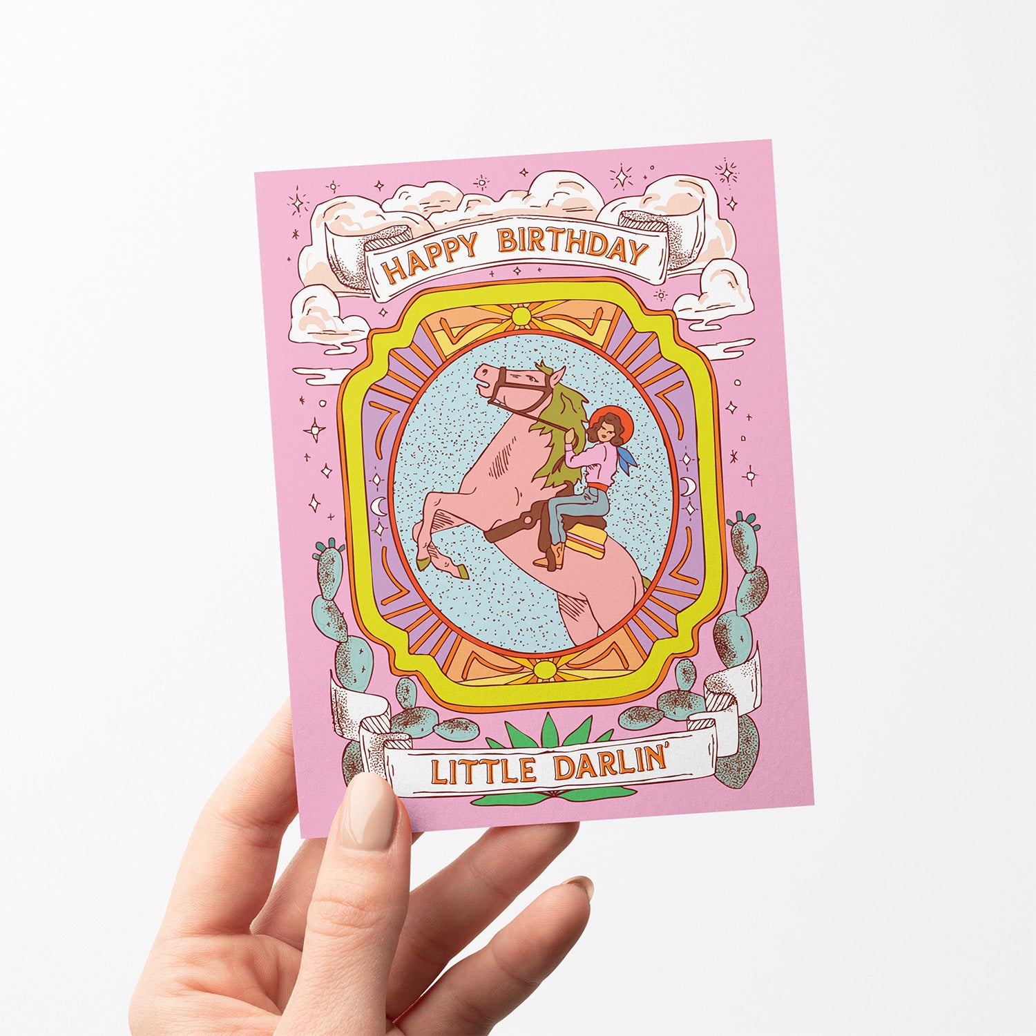 Western-themed pink birthday card with cowgirl riding a horse and the text “Happy Birthday Little Darlin’.”