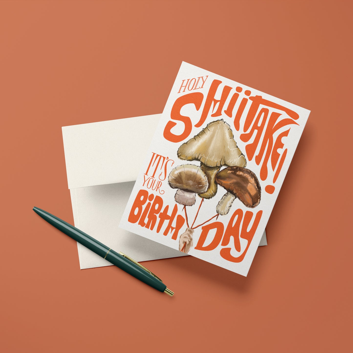 Humorous birthday card featuring a playful mushroom balloons with the phrase 'Holy Shiitake,' perfect for a lighthearted celebration.