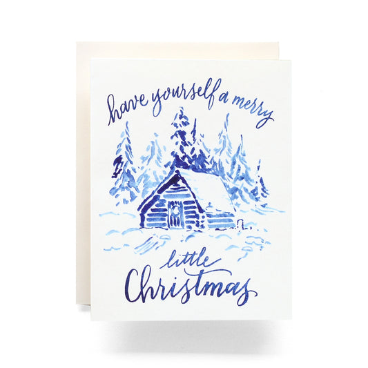 Indigo Little Christmas card featuring a watercolor scene of a cabin in the woods, perfect for a minimalist holiday greeting, blank inside.