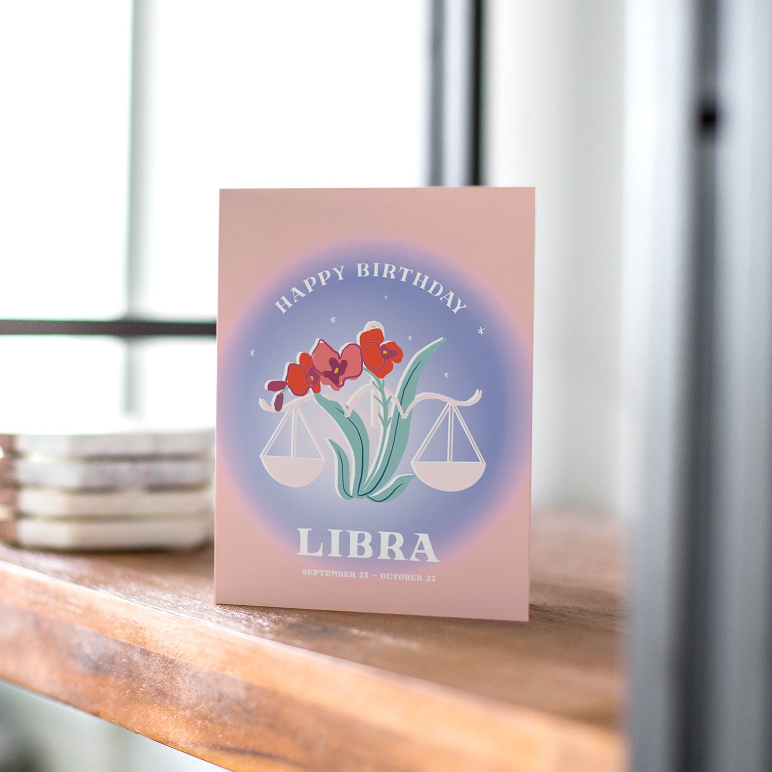 Balanced birthday card featuring the Libra symbol with harmonious colors and scales, embodying Libra's love for beauty and harmony.