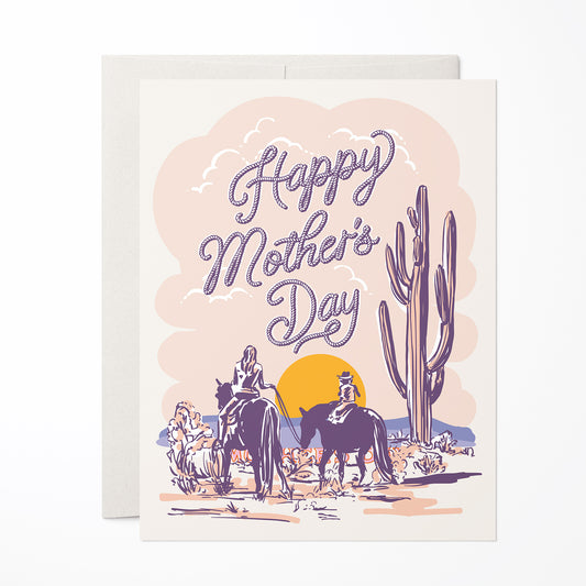 Mother’s Day card featuring an illustration of a mother and child on horses in a pastel desert landscape.