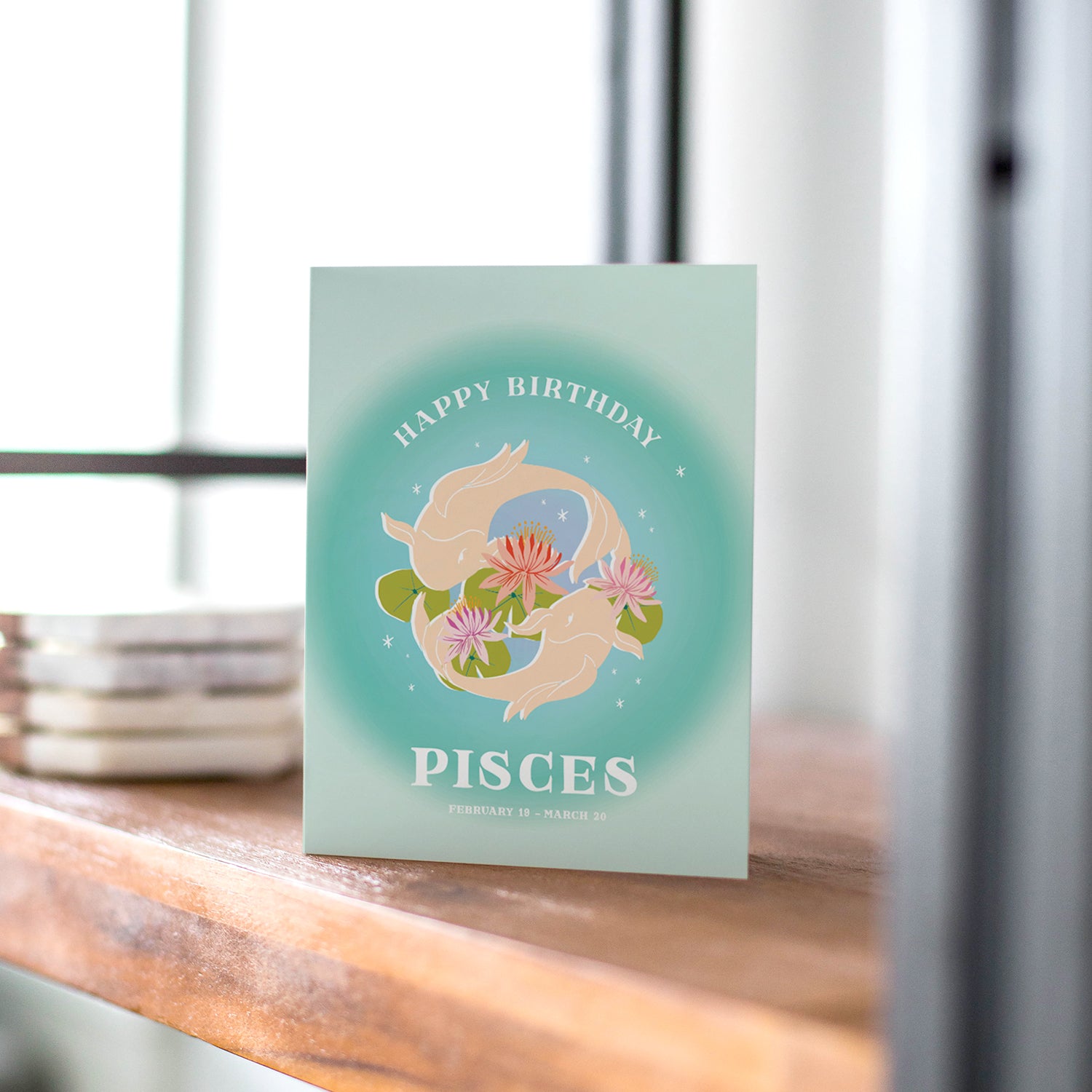 Dreamy birthday card with the Pisces symbol, featuring two fish swimming in a circle and soft greens to represent Pisces's empathy and creativity.