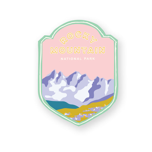 A Rocky Mountain National Park sticker featuring iconic Mountain landscape, including mountains, trees, and field of flowers, perfect for outdoor enthusiasts and nature lovers.